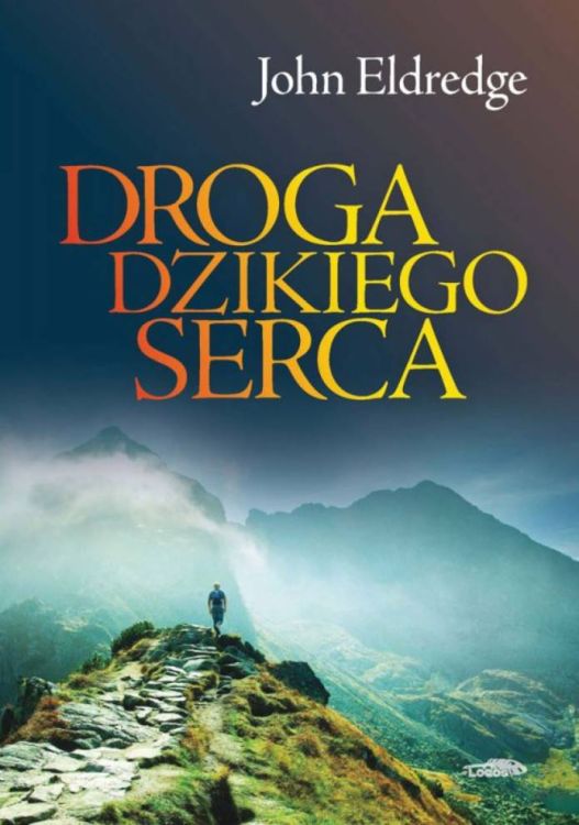 Okładka książki "Droga dzikiego serca" autorstwa Johna Eldredge'a. Przedstawia mężczyznę stojącego na górskim szlaku, wpatrzonego w zamglone szczyty.