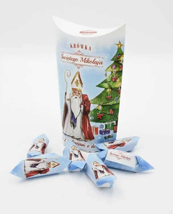 Krówki świętego Mikołaja - opakowanie z wizerunkiem biskupa Mikołaja w stroju liturgicznym przy choince | sklep chrześcijański
