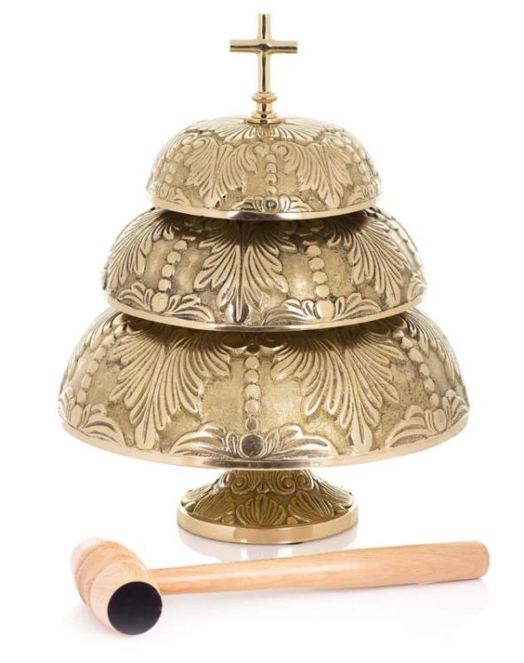 Bogato zdobiony, trójpoziomowy gong liturgiczny z mosiądzu, zwieńczony krzyżem, stojący na białym tle obok drewnianego młotka | sklep z artykułami sakralnymi