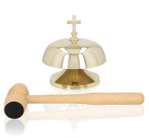Mosiężny, złoty gong liturgiczny na stabilnej podstawie, zwieńczony krzyżem. Obok leży drewniany młotek | SKLEP LITURGICZNY