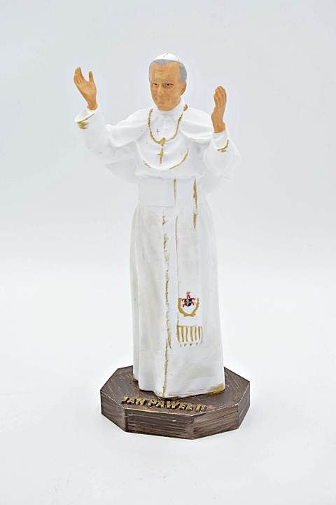 Figura św. Jana Pawła II w geście błogosławieństwa, wysokość 21 cm, widok całej postaci na brązowej podstawie z napisem.