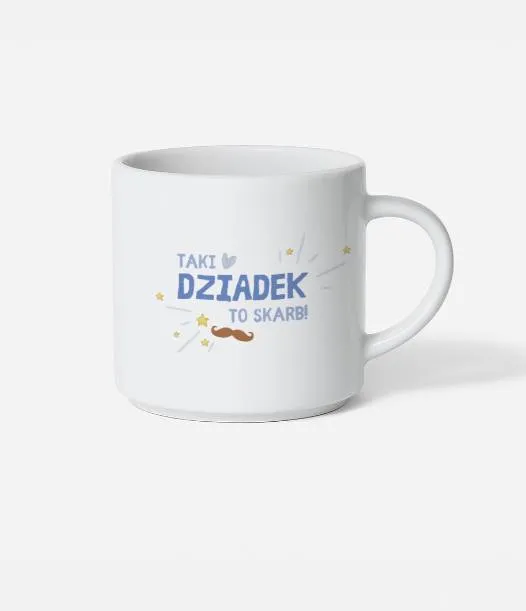 Biały kubek z błękitnym napisem Taki Dziadek to skarb trzymany w dłoniach