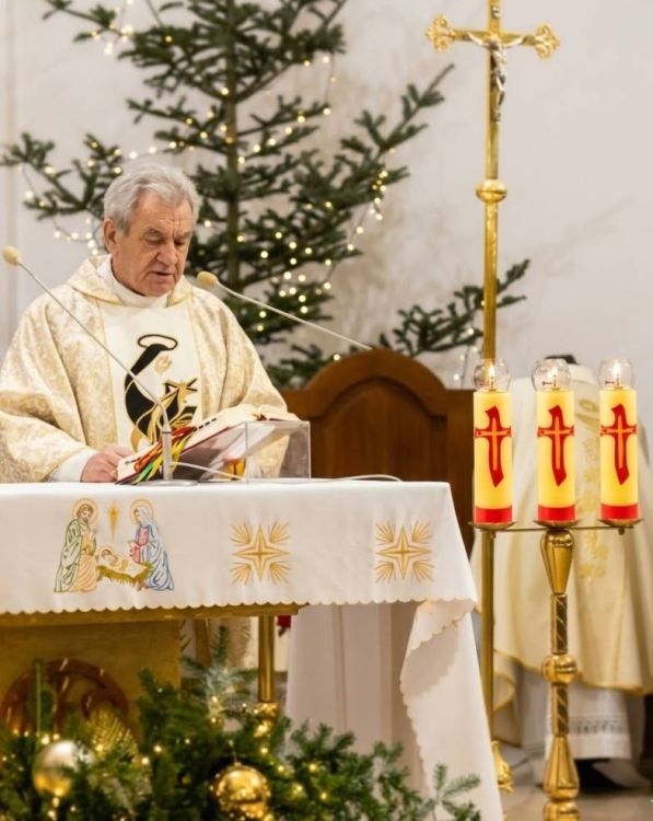 świeca ołtarzowa olejowa żółta z krzyżem czerwonym 30 cm na świeczniku przy ołtarzu podczas Mszy Świętej Bożego Narodzenia