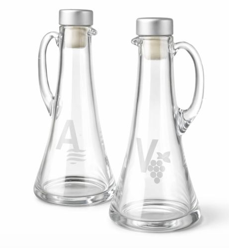 Komplet ampułek liturgicznych z grubego szkła 100 ml — oznaczenia A (woda) i V (wino), korki metalowe srebrne, producent Releif