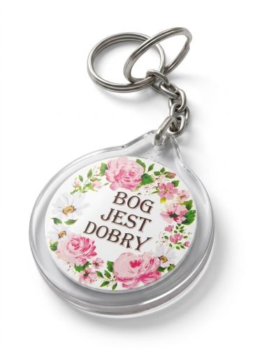 Plastikowy dwustronny brelok 40 mm z napisem „Bóg jest dobry" i kwiatowym wieńcem. Metalowe kółko, motyw po obu stronach, drobny codzienny akcent.