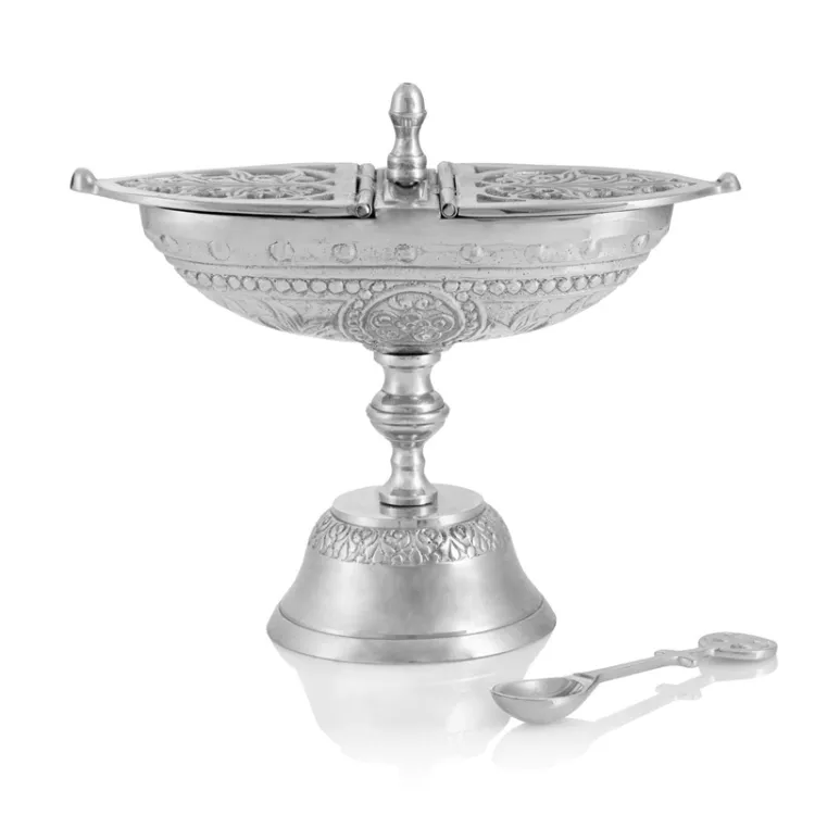 Detal naczynia liturgicznego z mosiądzu niklowanego, pokazujący lustrzane wykończenie powierzchni i profilowaną łyżeczkę do nakładania kadzidła.