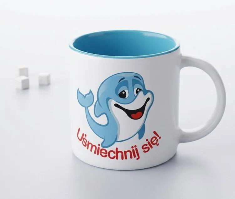 Biały ceramiczny kubek 400 ml z niebieskim wnętrzem i nadrukiem uśmiechniętego delfina z napisem Uśmiechnij się — e-religijne.pl