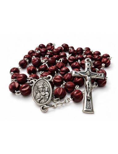 Wiśniowy różaniec z nacinanymi paciorkami, łącznikiem z Matką Bożą Częstochowską i krzyżykiem na białym tle.