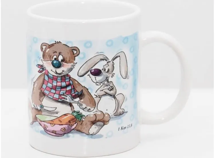 Kubek z parą misiów jedzących posiłek przy stole i napisem Miłość nigdy nie ustaje.